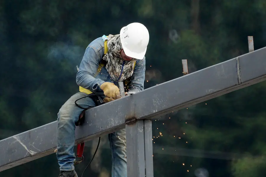 Trabajador industrial con equipo de seguridad realizando soldadura